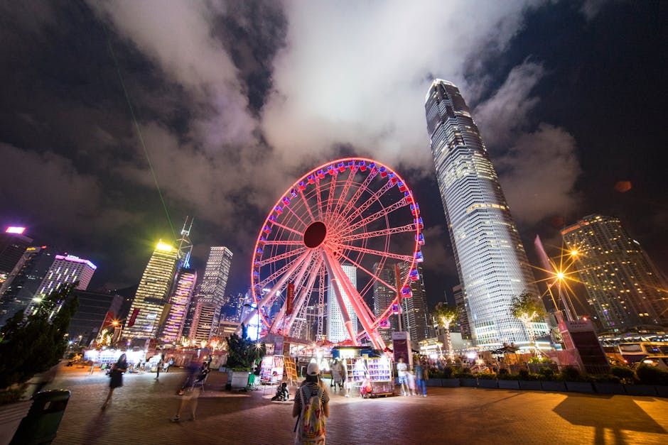 Captivating nighttime scene of Hong Kong's illuminated Ferris wheel against a vibrant cityscape.