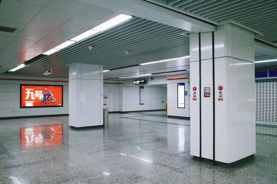 A spacious and modern metro station interior with an advertising board and reflective flooring, captured in high-quality detail.